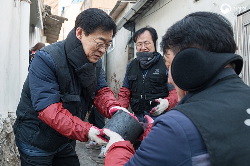 장동언 기상청장과 기상청 직원들이 연탄을 손으로 배달하는 모습